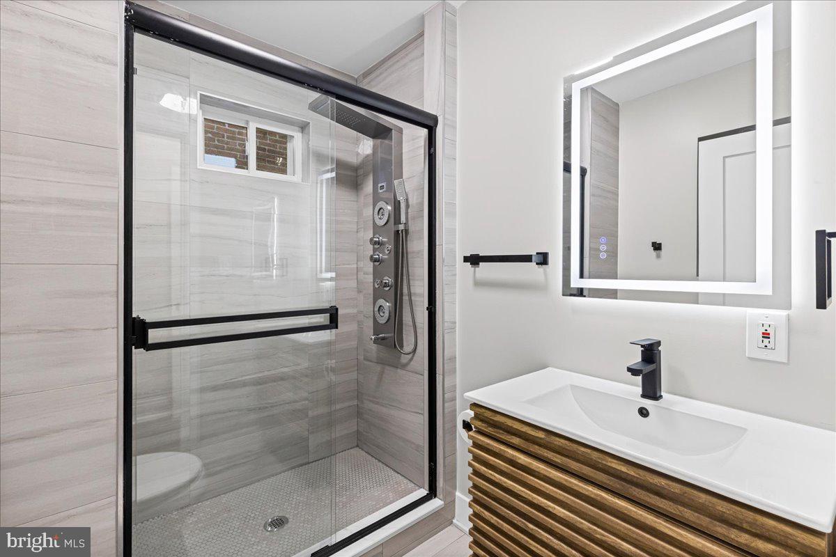 6629 Ross Street Philadelphia, PA 19119 - Photo 15 of 26 a bathroom with a sink a mirror and a shower