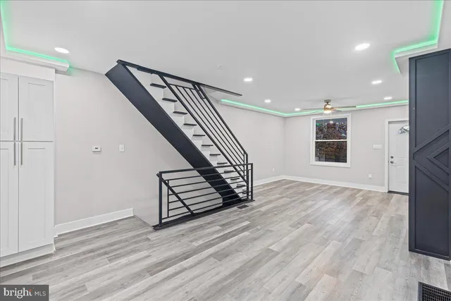 a view of a hallway with wooden floor and staircase