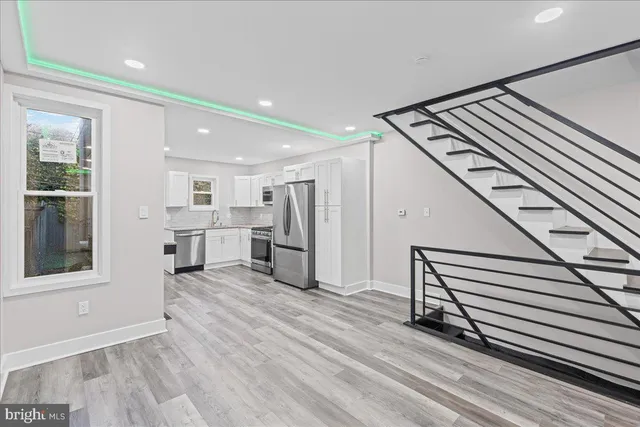 a kitchen with granite countertop a stove a sink and a refrigerator