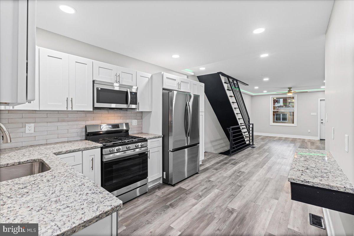 6629 Ross Street Philadelphia, PA 19119 - Photo 9 of 26 a kitchen with granite countertop a stove a sink and a refrigerator