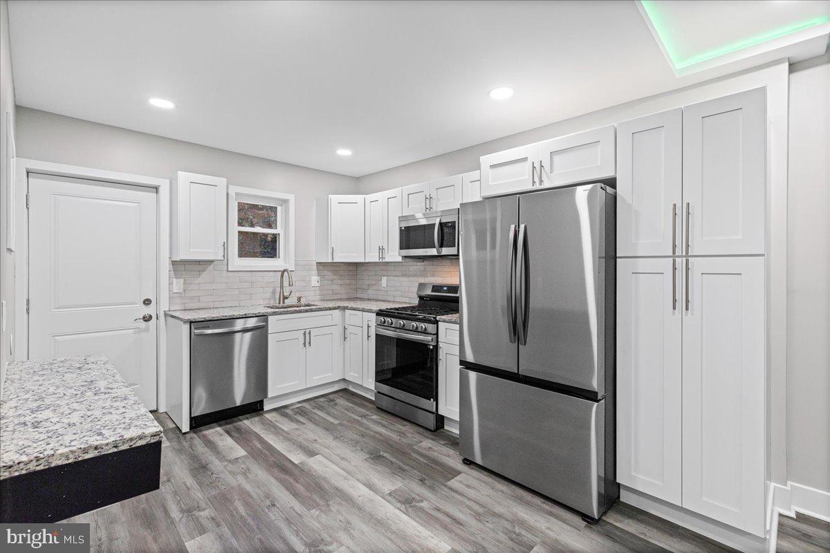 6629 Ross Street Philadelphia, PA 19119 - Photo 10 of 26 a kitchen with a refrigerator stainless steel appliances wooden floor and cabinets