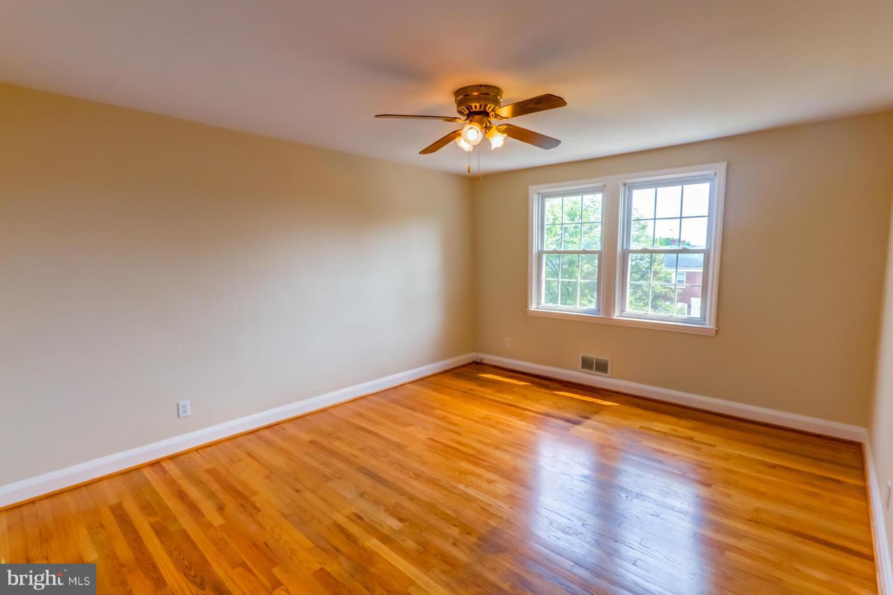 1546 Northbourne Road Baltimore, MD 21239 - Photo 12 of 18 a view of an empty room with wooden floor and a window