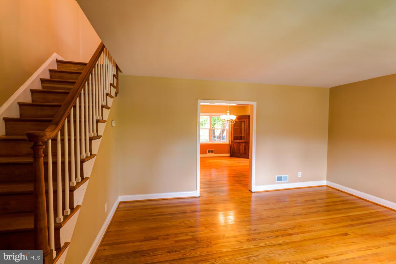1546 Northbourne Road Baltimore, MD 21239 - Photo 6 of 18 a view of an empty room with wooden floor and stairs