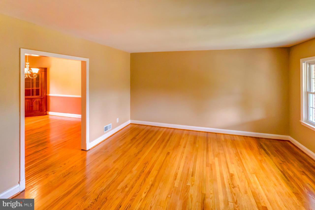 1546 Northbourne Road Baltimore, MD 21239 - Photo 7 of 18 a view of an empty room with wooden floor and a window