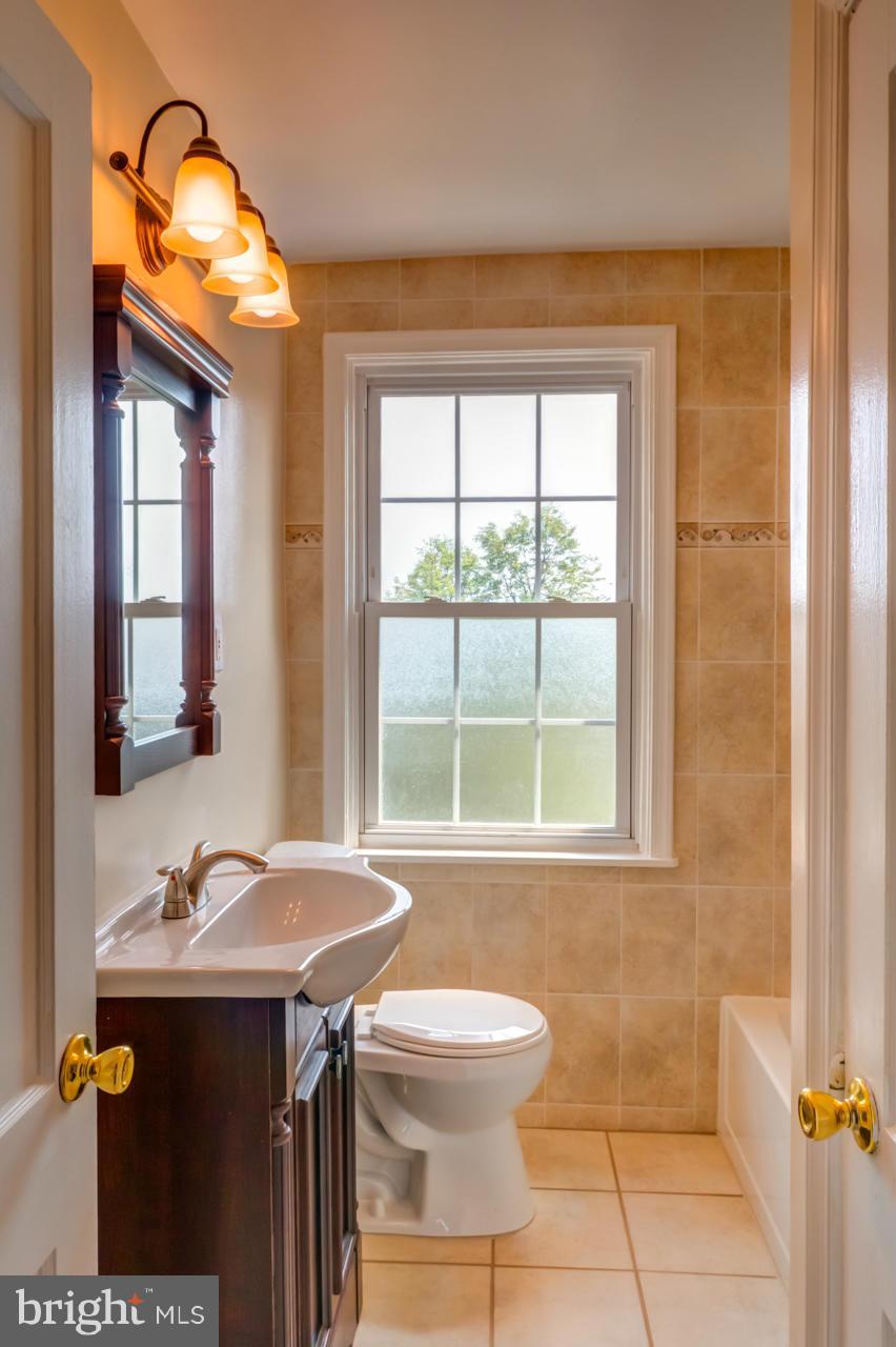 1546 Northbourne Road Baltimore, MD 21239 - Photo 10 of 18 a bathroom with a sink a toilet and a mirror
