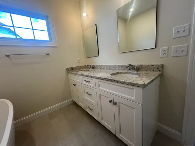 a bathroom with a granite countertop sink a mirror and a window