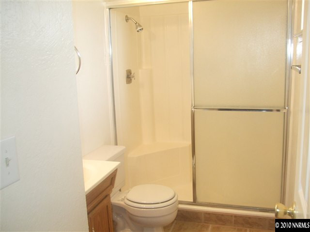 10012 Albite Street Reno, NV 89506 - Photo 7 of 9 a bathroom with a granite countertop shower and a toilet