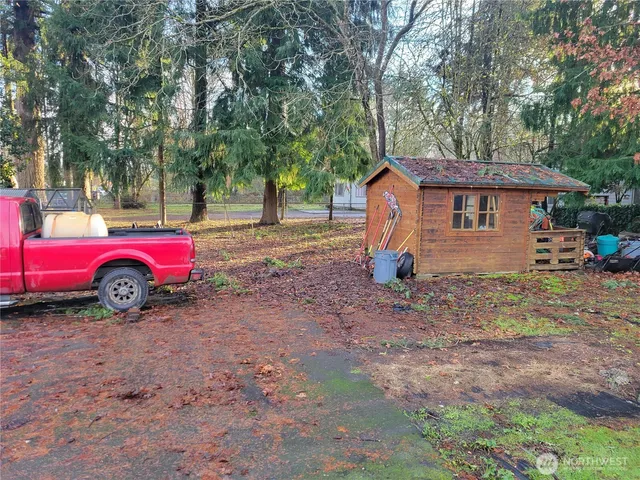 a view of a house with a backyard and trees