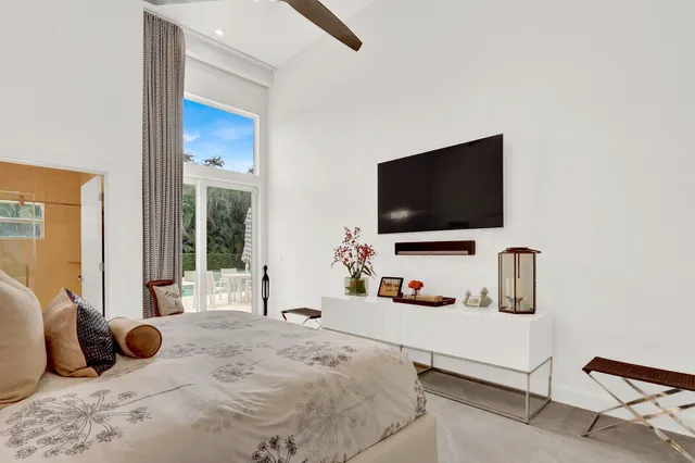 a bedroom with a bed and a flat tv screen on dresser