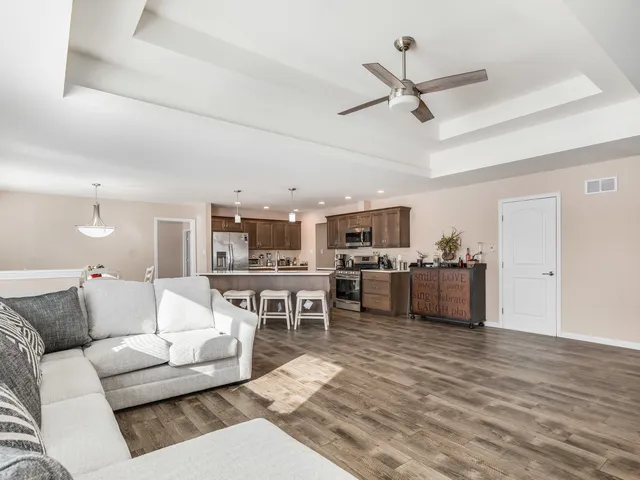 a living room with furniture kitchen view and a window