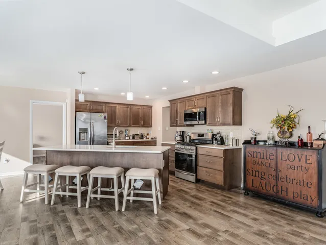 a large kitchen with cabinets a sink and stainless steel appliances