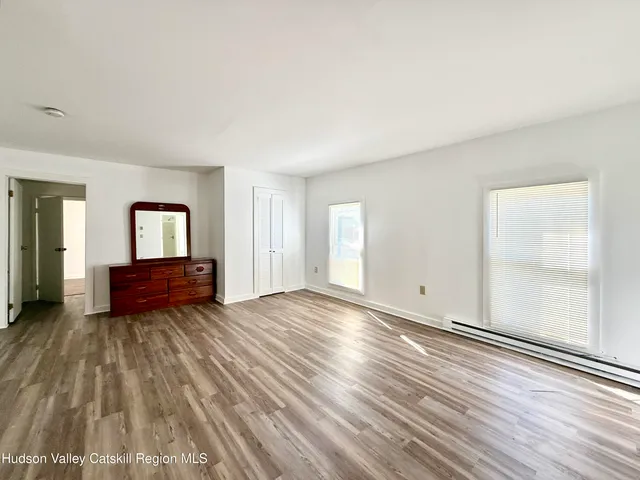 a view of empty room with wooden floor and window