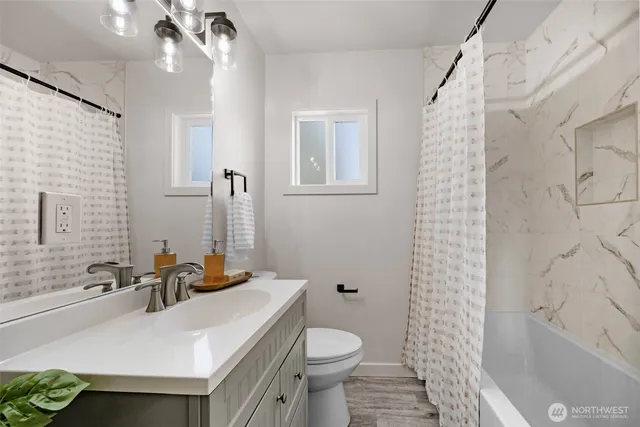 a bathroom with a sink a toilet and shower