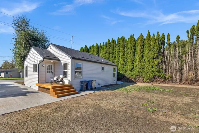 a view of a house with backyard and trees