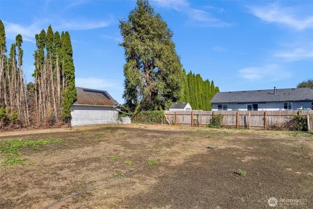 a view of a house with backyard and trees