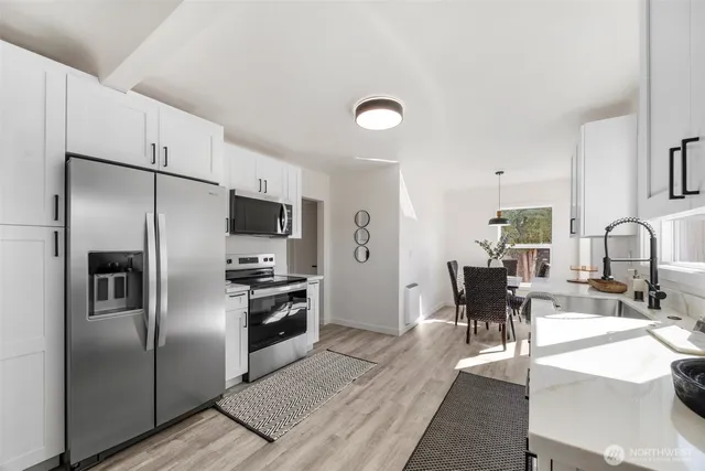 a kitchen with stainless steel appliances kitchen island granite countertop a refrigerator a stove a sink and dishwasher