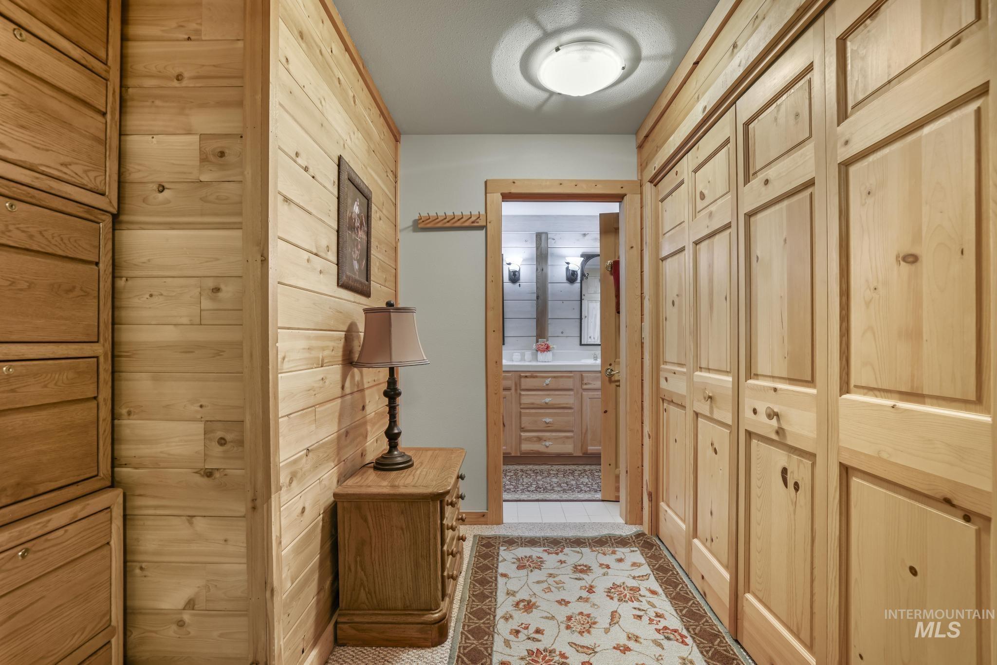 203 North Brush Road Fairfield, ID 83327 - Photo 19 of 50 Hallway featuring wood walls and light tile patterned floors