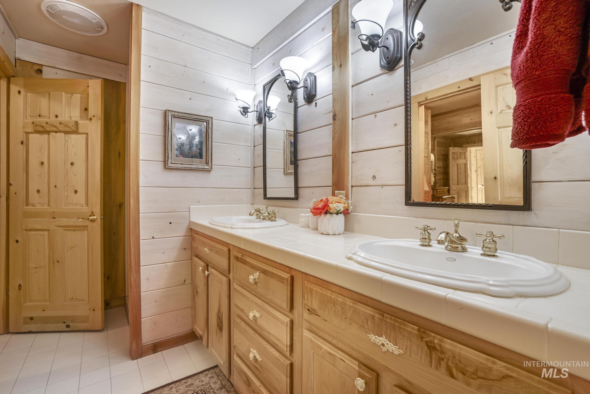 203 North Brush Road Fairfield, ID 83327 - Photo 20 of 50 Bathroom with double vanity and wood walls