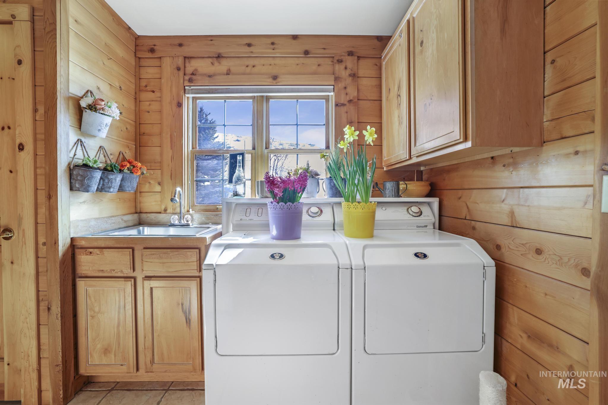 203 North Brush Road Fairfield, ID 83327 - Photo 21 of 50 Laundry area featuring wooden walls, cabinet space, independent washer and dryer, and light tile patterned flooring