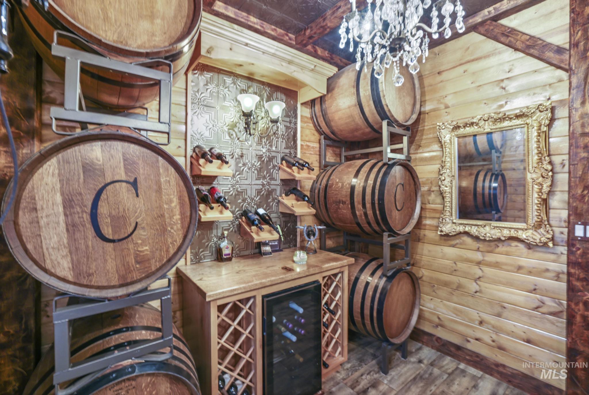 203 North Brush Road Fairfield, ID 83327 - Photo 26 of 50 Wine cellar featuring beverage cooler, wood finished floors, a chandelier, and wooden walls