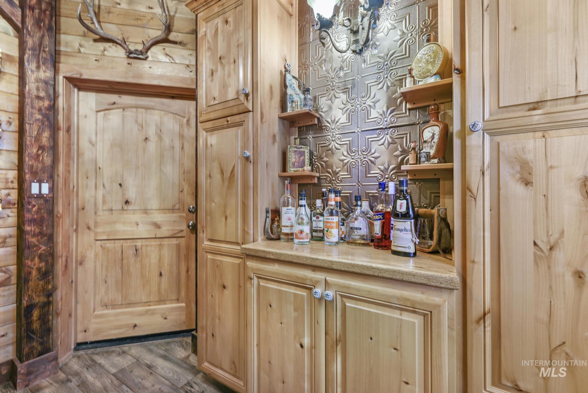 203 North Brush Road Fairfield, ID 83327 - Photo 27 of 50 Bar area with wooden walls and wood finished floors