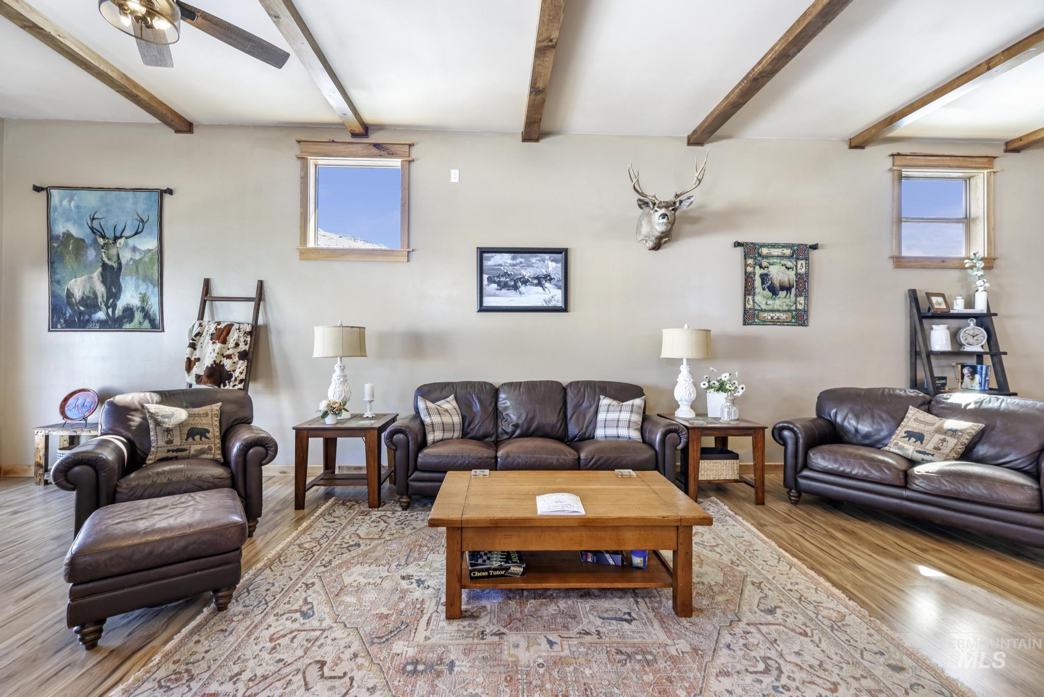 203 North Brush Road Fairfield, ID 83327 - Photo 44 of 50 Living room featuring light wood-style floors, healthy amount of natural light, beam ceiling, and a ceiling fan