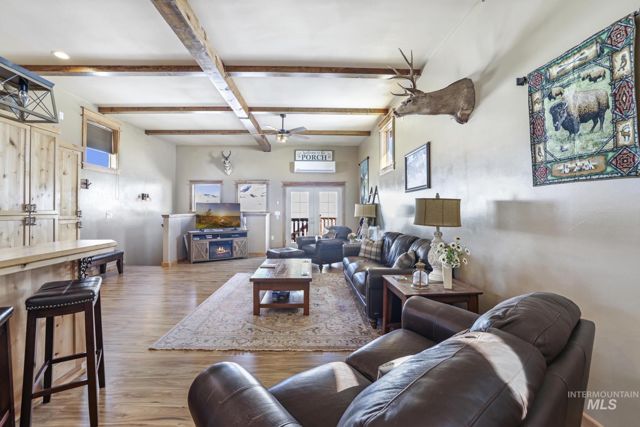 203 North Brush Road Fairfield, ID 83327 - Photo 47 of 50 Living area featuring beamed ceiling, wood finished floors, ceiling fan, and french doors