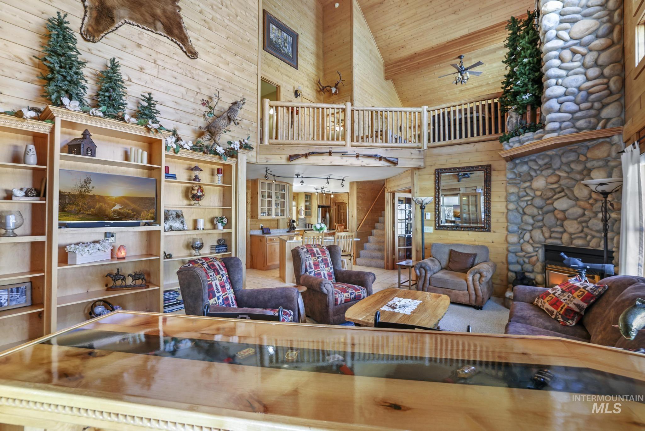 203 North Brush Road Fairfield, ID 83327 - Photo 8 of 50 Living room with wooden walls, a towering ceiling, stairway, a ceiling fan, and wood ceiling