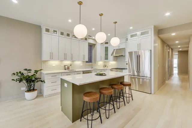 a kitchen with stainless steel appliances kitchen island granite countertop a stove a sink and a refrigerator