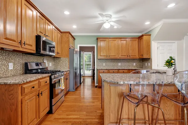 a kitchen with stainless steel appliances granite countertop a sink a stove and cabinets