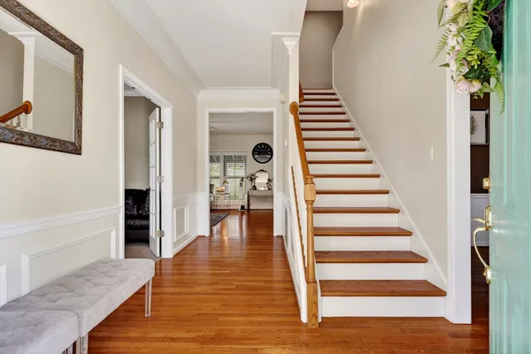 a view of a hallway with wooden floor and staircase