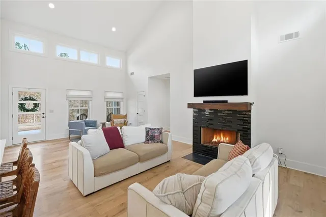 a kitchen with stainless steel appliances kitchen island a table chairs and a refrigerator