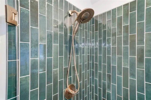 a bathroom with a toilet a sink a glass door shower and a mirror