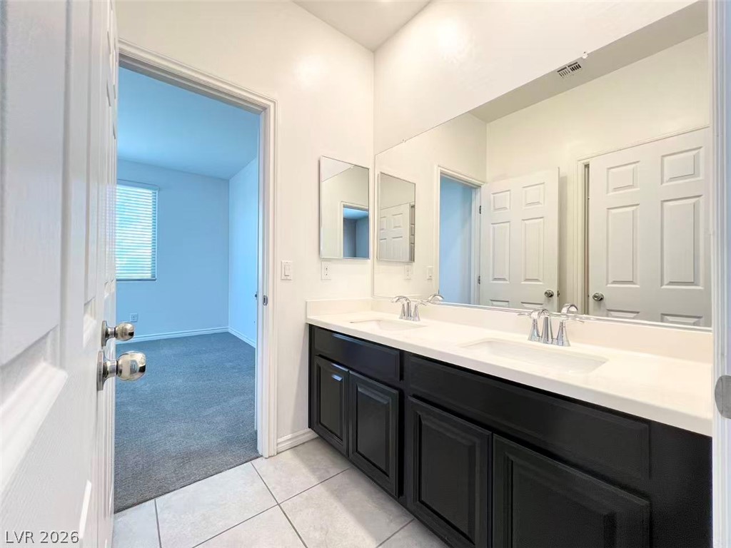 925 Bayberry Ridge Street Henderson, NV 89052 - Photo 20 of 27 Double vanity in a bathroom with crisp white cabinets and gleaming chrome fixtures.