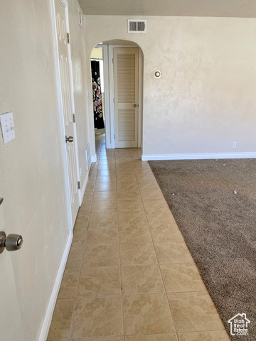 247 West 400 North, Unit 1 Moab, UT 84532 - Photo 7 of 27 Corridor featuring arched walkways, light tile patterned floors, and light carpet