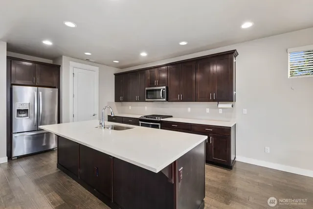 a kitchen with kitchen island a sink stainless steel appliances and cabinets