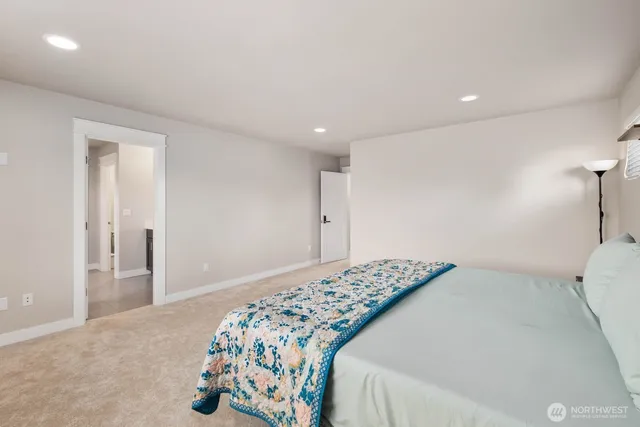 a bedroom with a bed and a painting on the wall