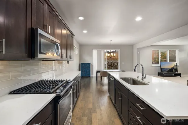 a kitchen with stainless steel appliances a sink stove and cabinets