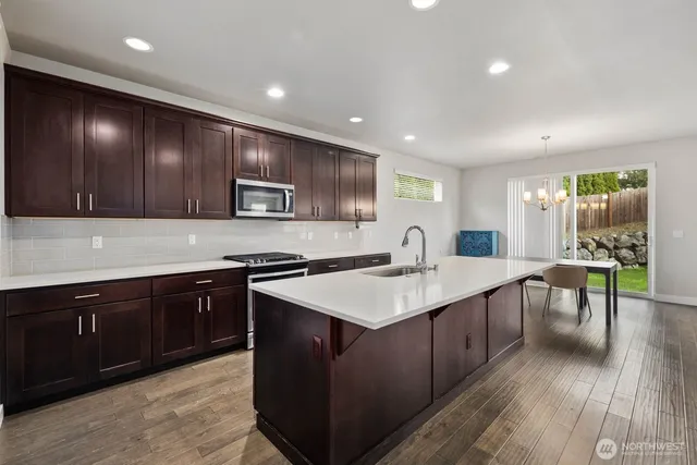 a kitchen with a sink cabinets and wooden floor