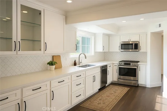 a kitchen with stainless steel appliances granite countertop a stove a sink and a microwave