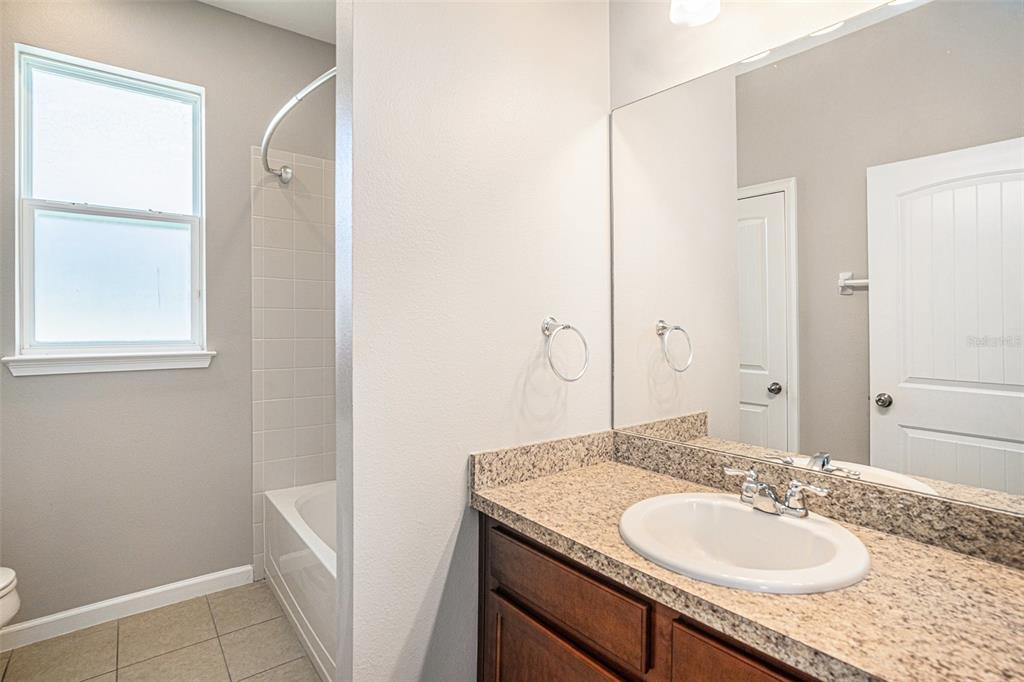 12314 Eagle Swoop Place Riverview, FL 33579 - Photo 14 of 23 a bathroom with a granite countertop sink and a mirror