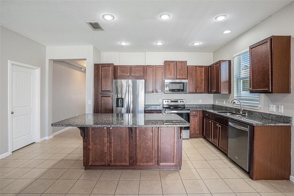 12314 Eagle Swoop Place Riverview, FL 33579 - Photo 9 of 23 a kitchen with stainless steel appliances granite countertop a refrigerator and a stove top oven