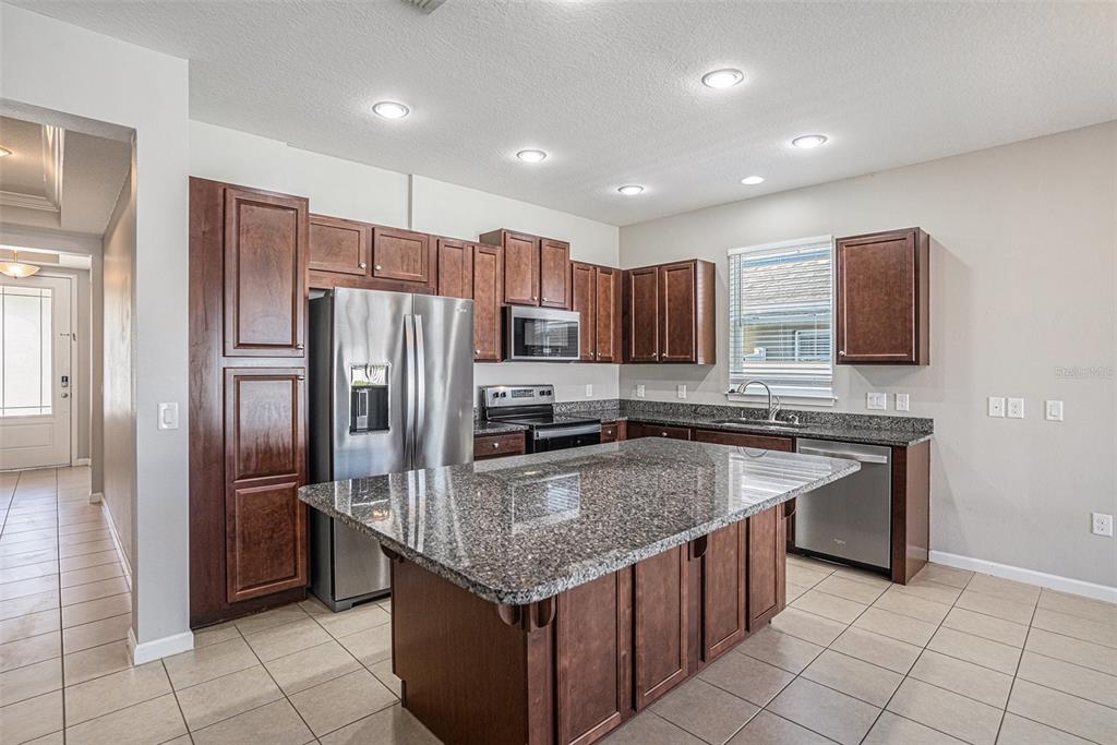12314 Eagle Swoop Place Riverview, FL 33579 - Photo 10 of 23 a kitchen with stainless steel appliances granite countertop a sink stove and refrigerator