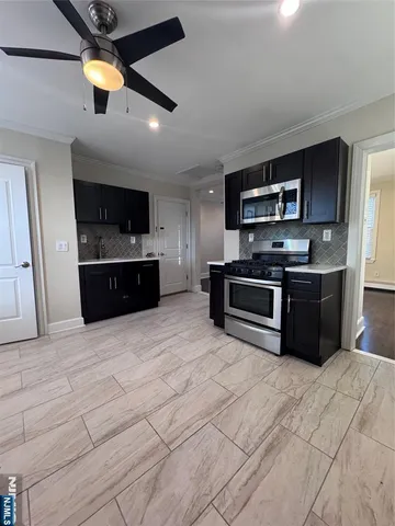 a large kitchen with stainless steel appliances granite countertop a stove and a sink