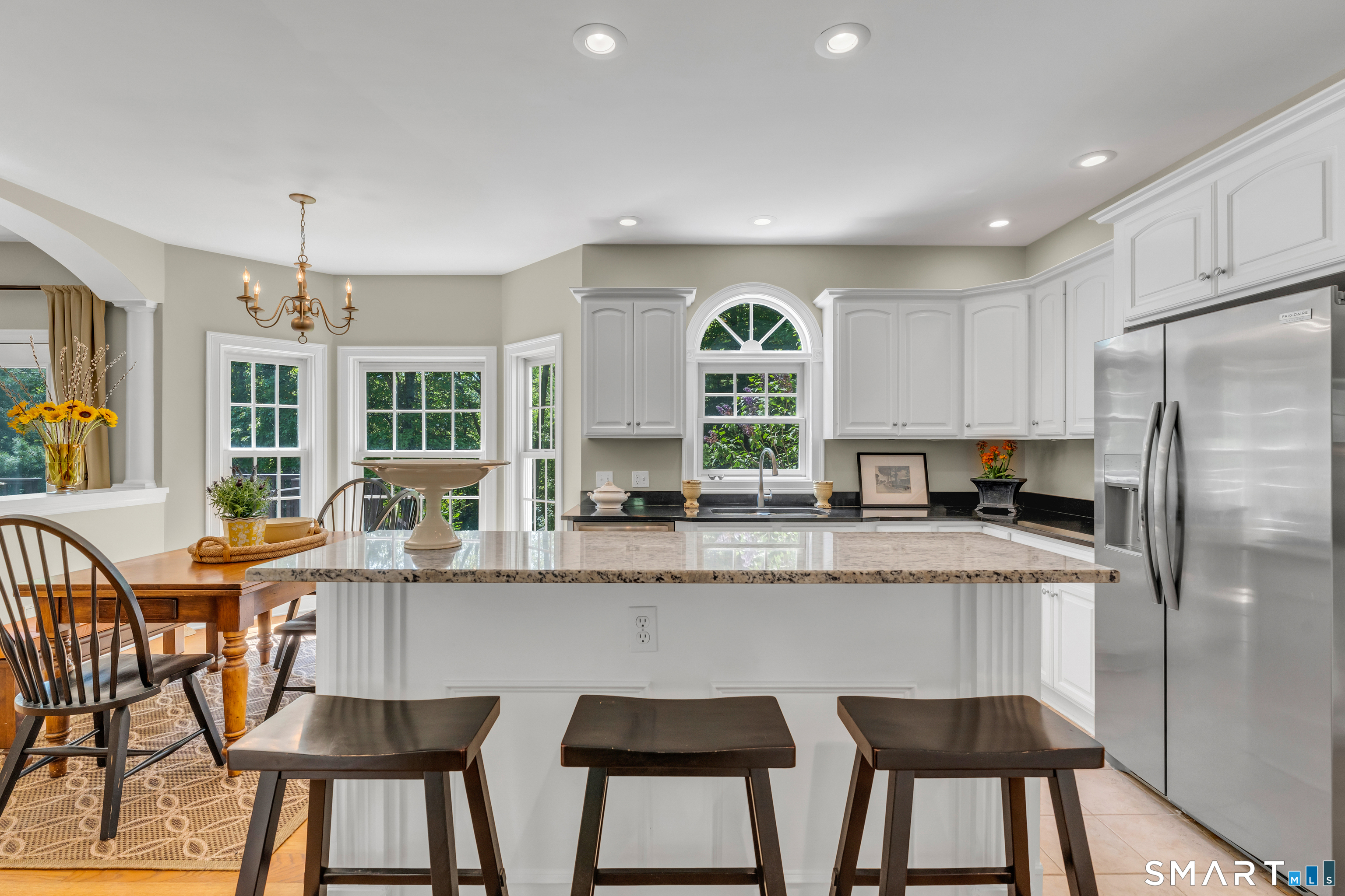 474 State Street Guilford, CT 06437 - Photo 12 of 40 a kitchen with stainless steel appliances granite countertop a table chairs refrigerator and cabinets