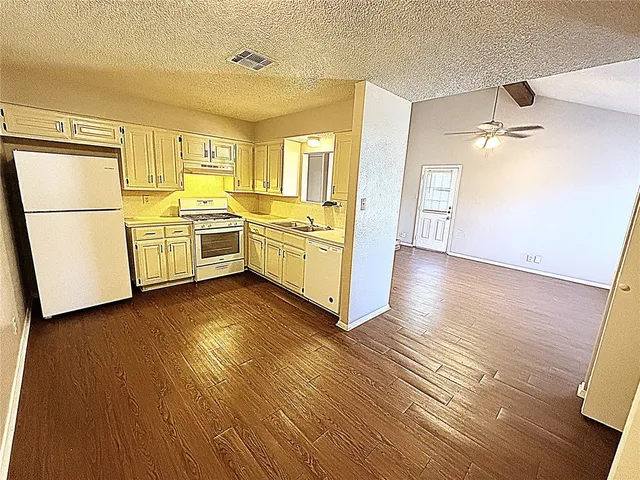 a kitchen with wooden floors and white appliances