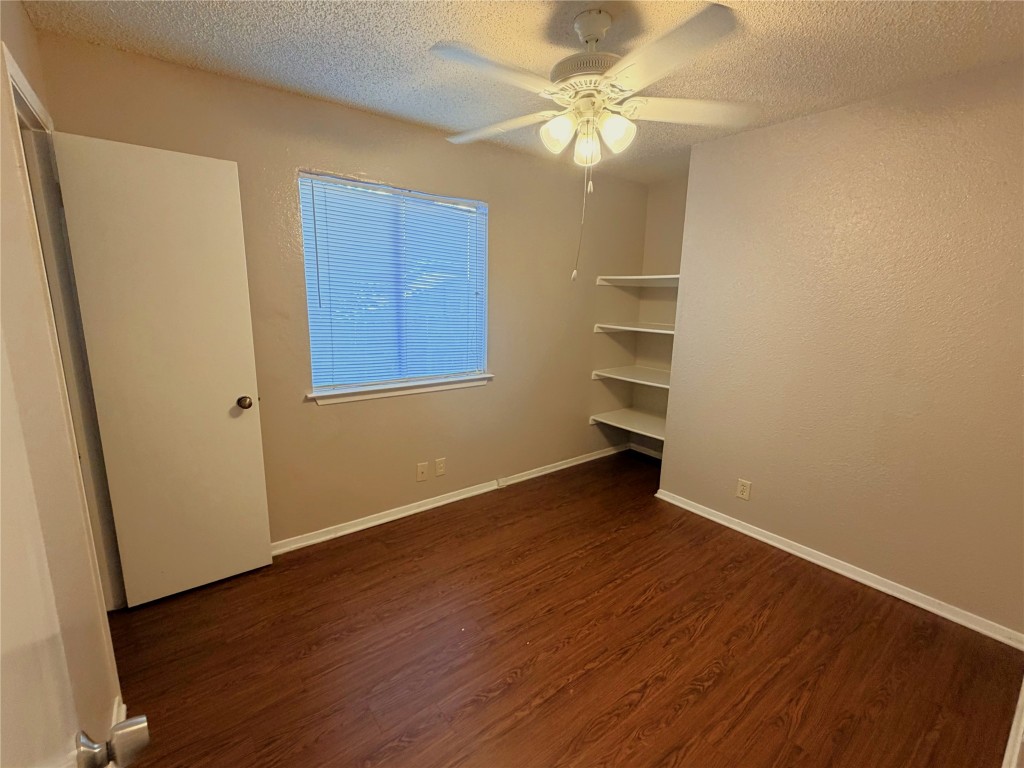 12800 Tomanet Trail, Unit B Austin, TX 78727 - Photo 7 of 12 an empty room with wooden floor and fan
