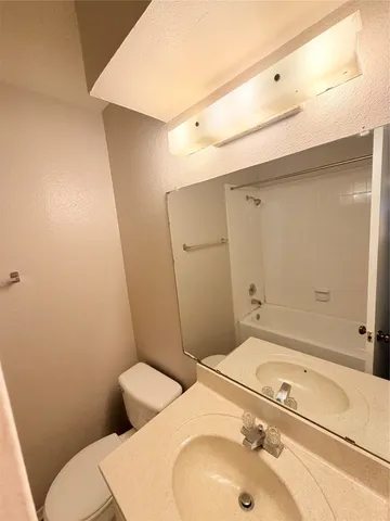a bathroom with a sink and mirror with toilet