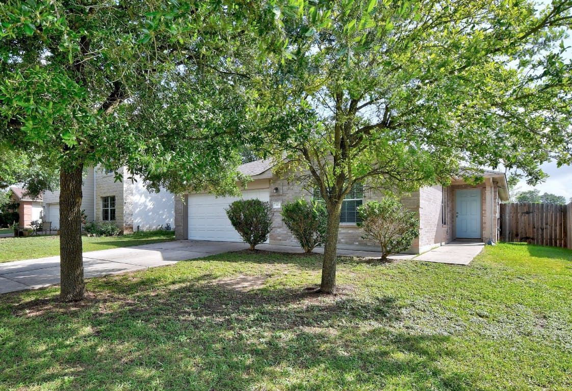a view of a house with a yard and tree