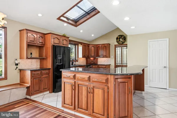 a kitchen with stainless steel appliances granite countertop a sink a stove a refrigerator and cabinets